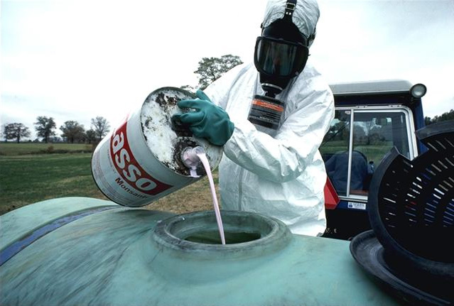 Landwirt gießt Pestizid in den Spritzertank