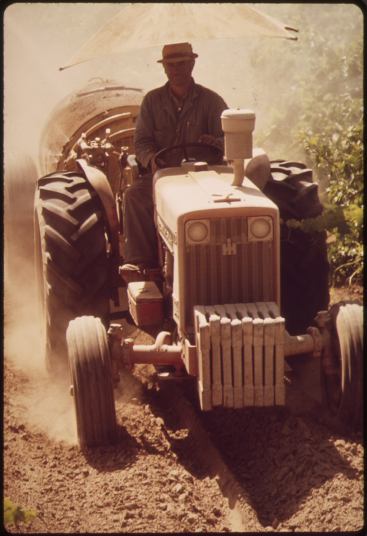 Bediener auf einem Traktor während der Bespritzung der Anlage